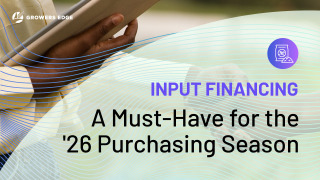 A person's hand holding a tablet. Layered atop are the words "Input Financing: A Must-Have for the '26 Purchasing Season"
